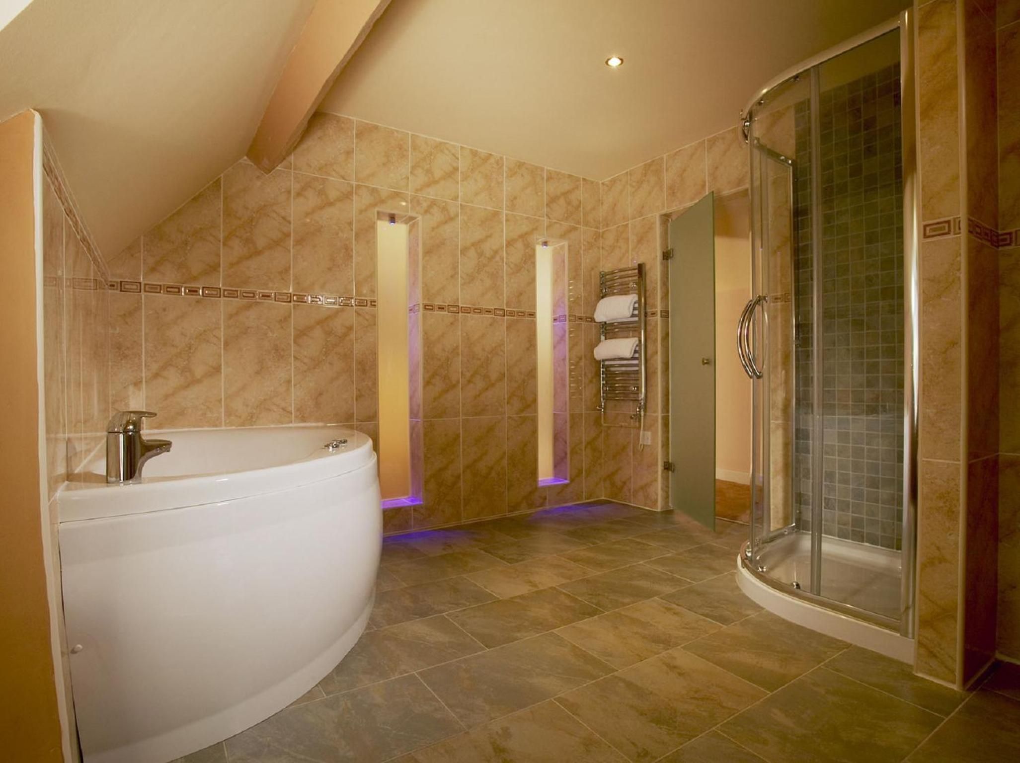 A bathroom with a large bathtub, a walk-in shower, and a glass door.