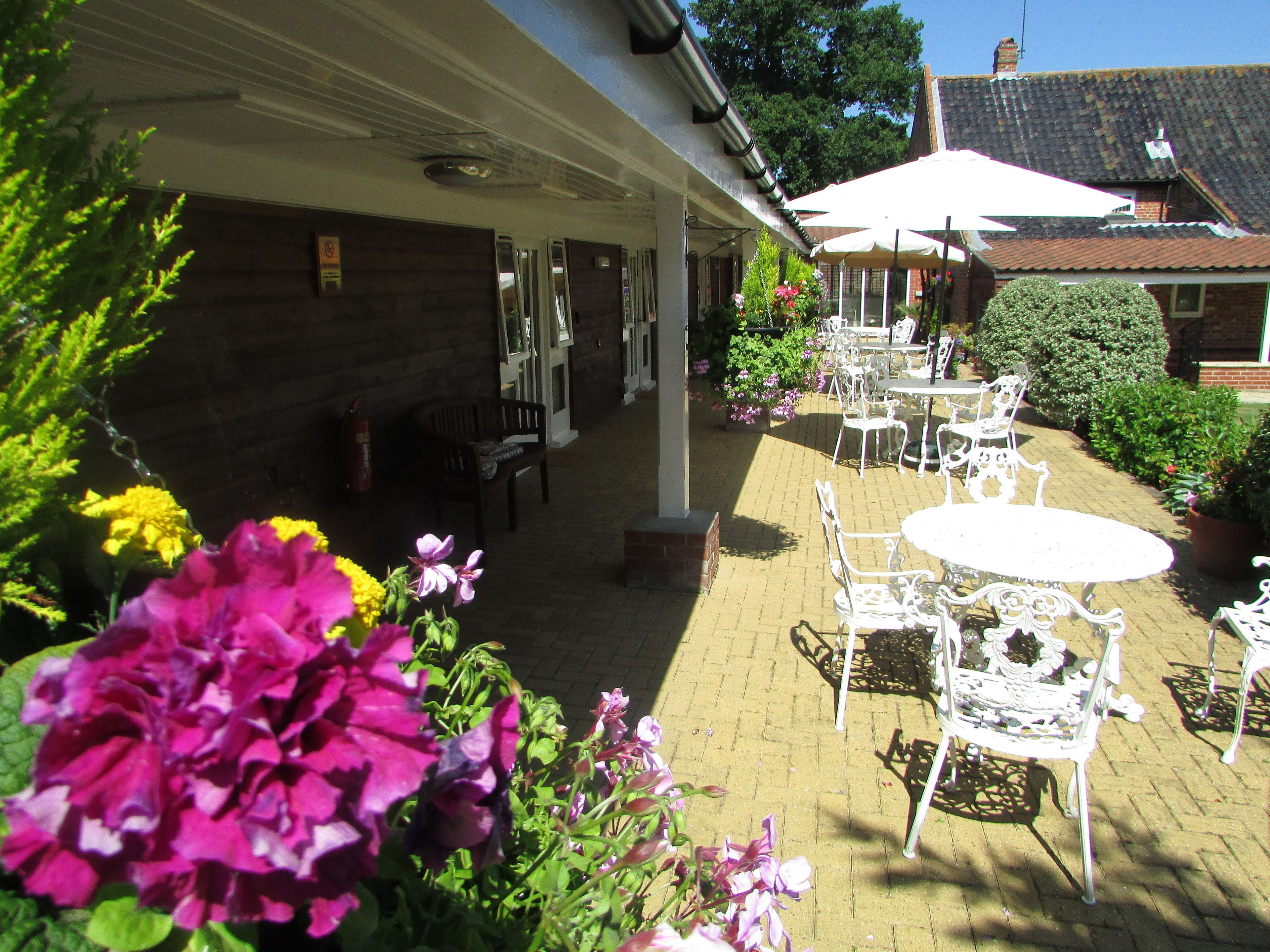 A covered patio area with outdoor seating and potted plants.