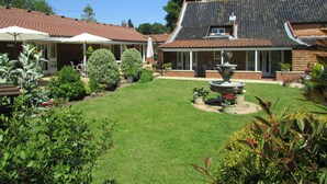 A house with a well-maintained lawn, a fountain, and potted plants. - Decoy Barn (Great Yarmouth)