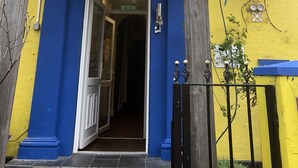 L’entrée d’un immeuble, avec une enseigne indiquant « Fawly Towers » et un numéro de téléphone.