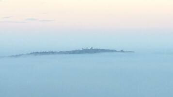 Una vista brumosa de un pueblo costero con edificios delineados contra la niebla.