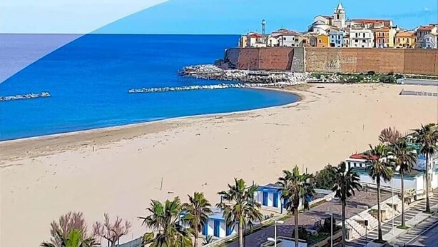 A coastal hotel with a beach view, palm trees, and a clear blue sky. - Meridiano (Termoli)