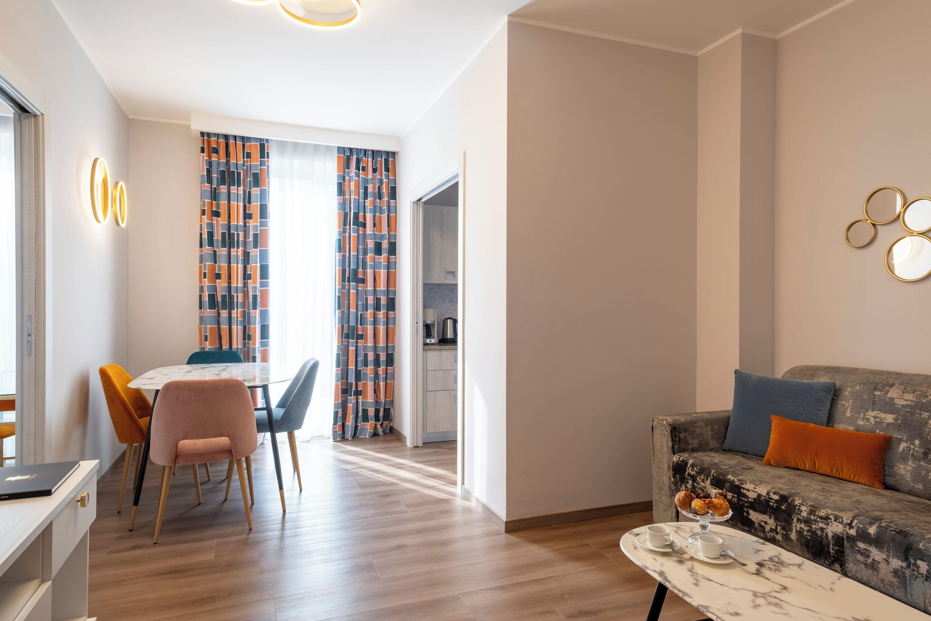 Een moderne woonkamer met een bank, een salontafel en een eethoek met een tafel en stoelen.