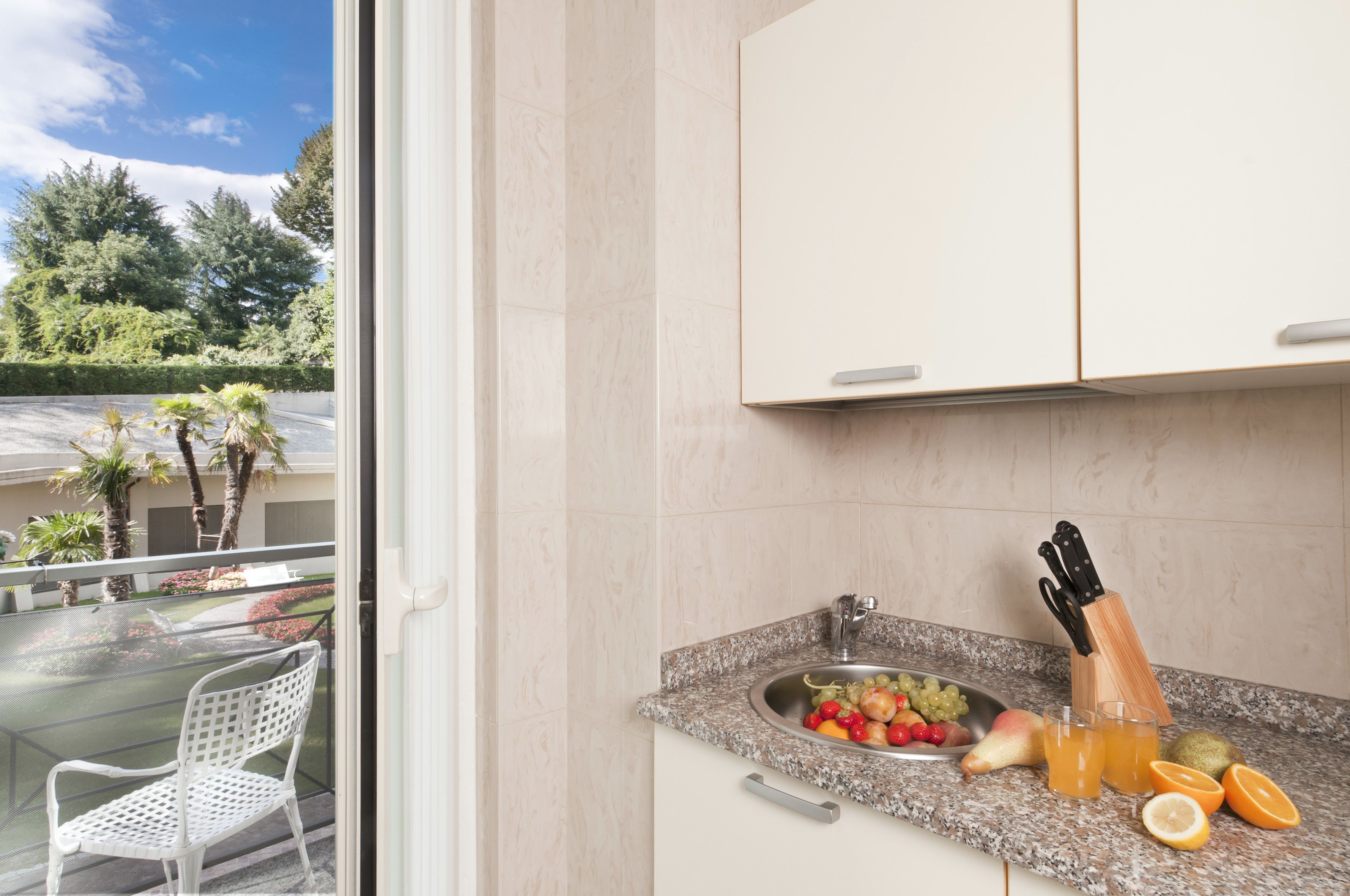 A kitchen with a granite countertop, a sink, and a fruit bowl.