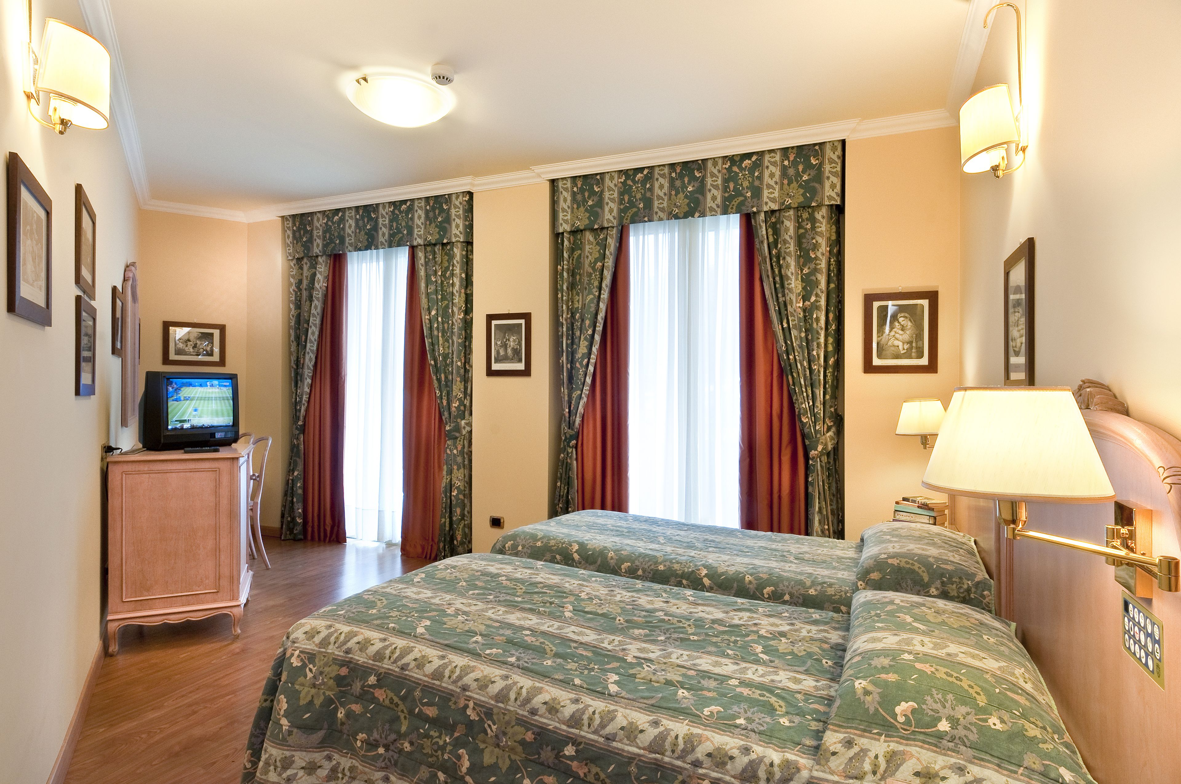 Een hotelkamer met een bed, een televisie en een kast.