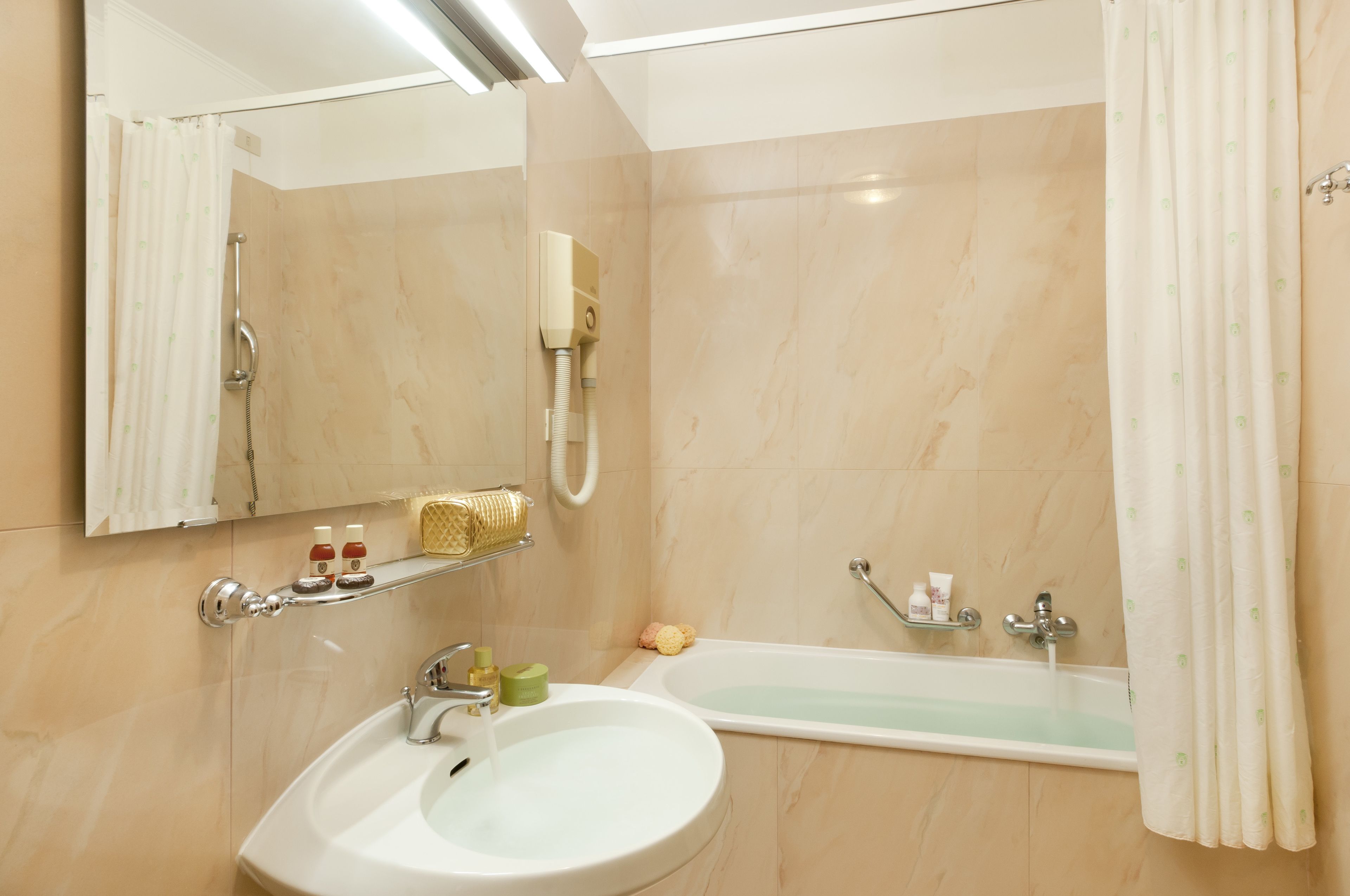 A bathroom with a sink, mirror, shower, and bathtub.