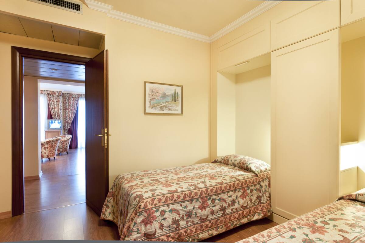 Un dormitorio con una cama, un armario y un cuadro en la pared.