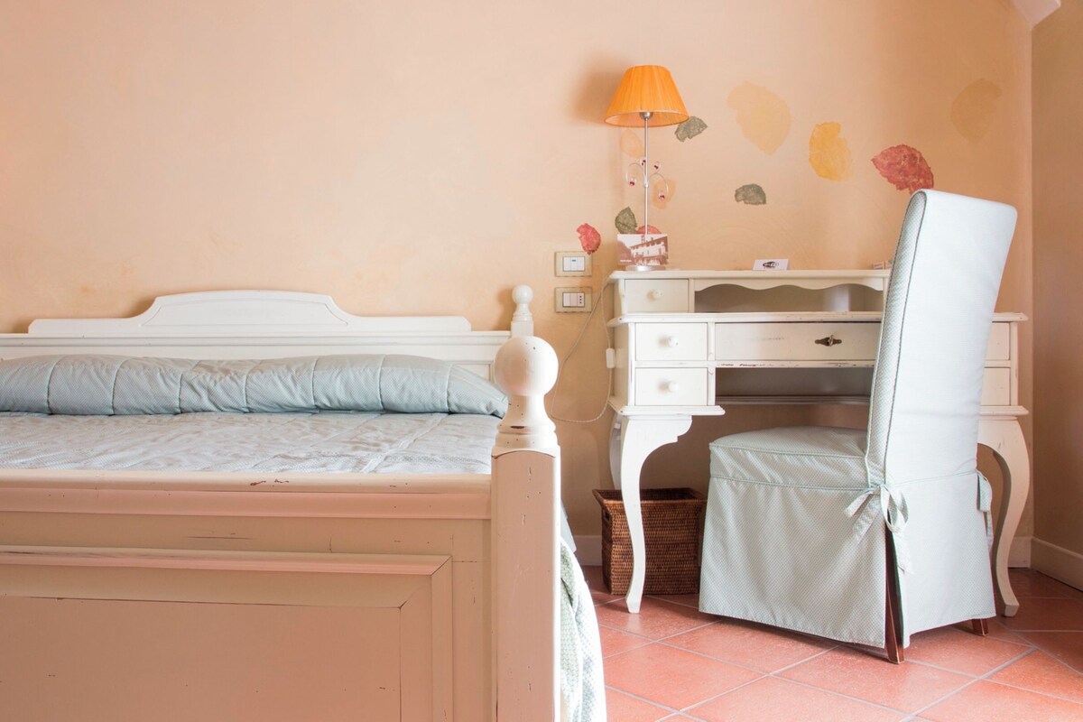 Un dormitorio con cama, escritorio y silla.