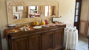 A buffet setup with various food items and a large mirror above it. - Tenuta La Cascinetta (Buriasco)