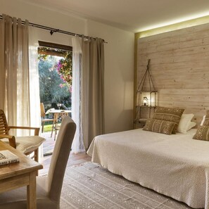 A bedroom with a bed, a bedside table, a chair, and a view of the outdoors. - Tenuta Pilastru (Arzachena)