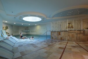 Una piscina techada, sillones reclinables de piscina