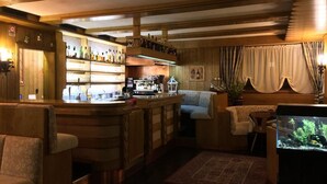Un rincón de bar acogedor con mobiliario de madera, una barra y un acuario.