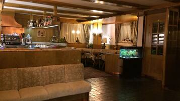 Un'accogliente area bar con un bancone in legno, una poltrona e un acquario.