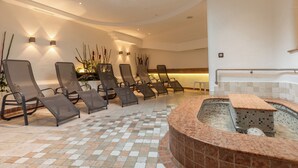 A spa area with reclining chairs, a hot tub, and a tiled floor. - Hotel Erna (Brennero)