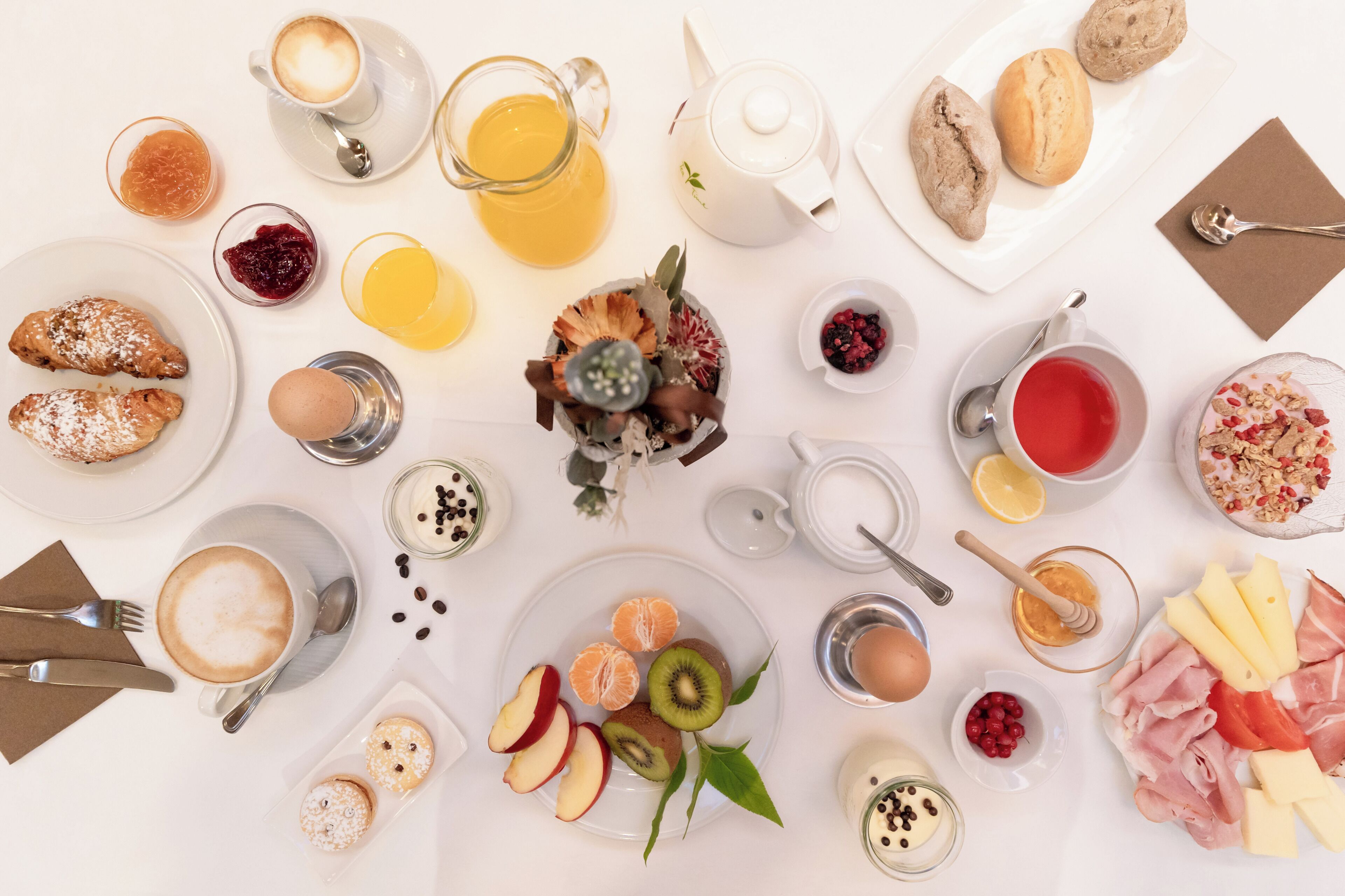 Una mesa con diversas opciones de comida y bebidas para el desayuno.