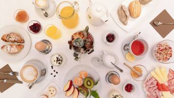 Una mesa con diversas opciones de comida y bebidas para el desayuno.
