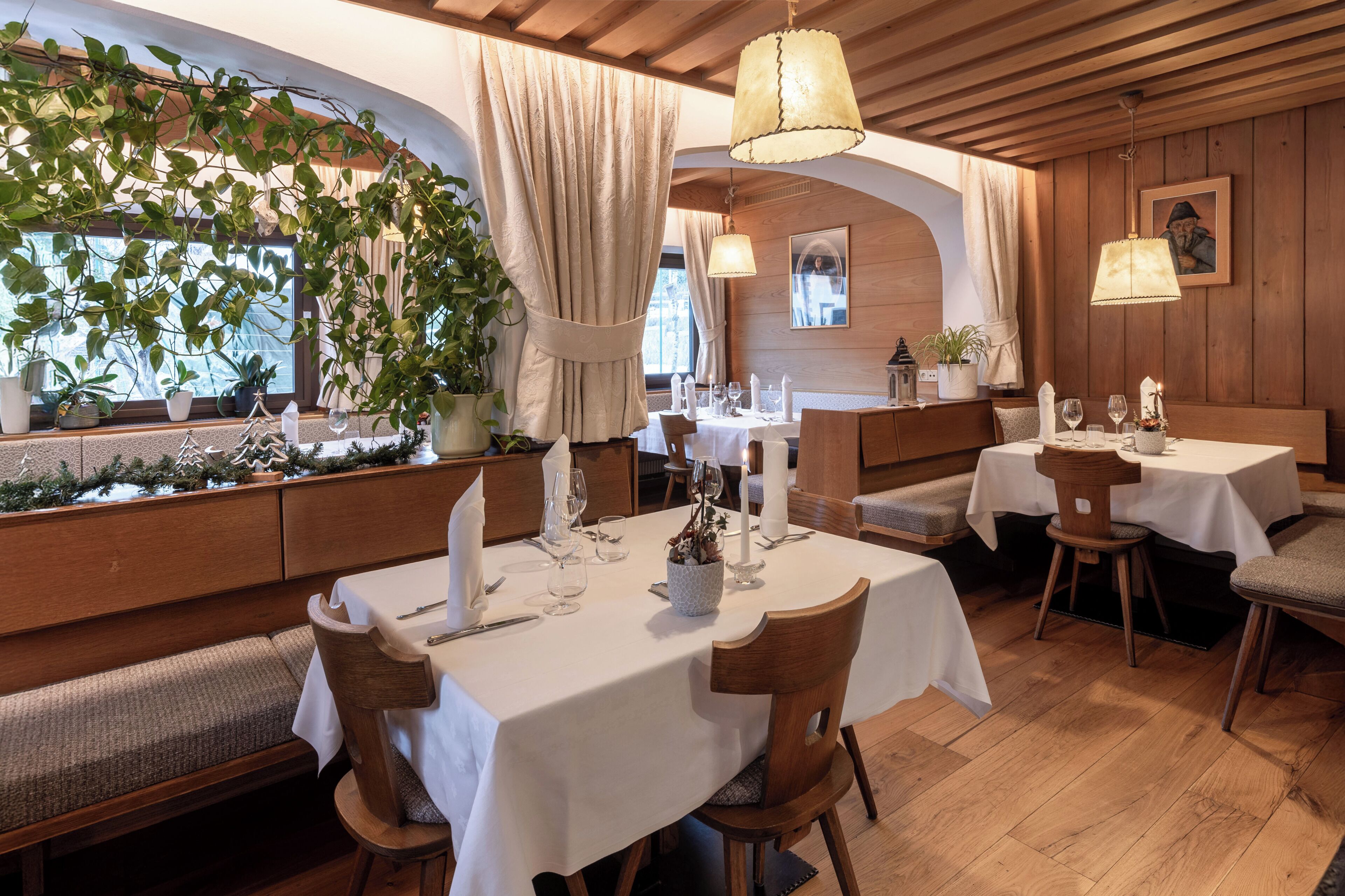 A restaurant with wooden walls, white tablecloths, and candlelit tables.