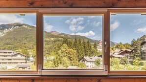 A view through three windows of a mountainous area with buildings and trees. - Hotel Erna (Brennero)