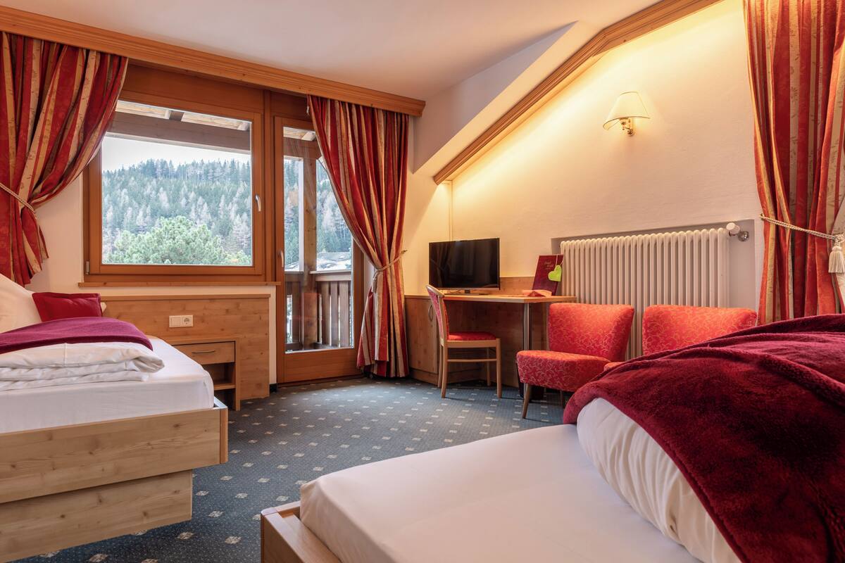 Een hotelkamer met een bed, bureau, stoel en een televisie.