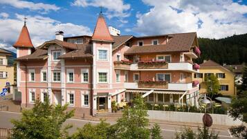 Un edificio rosa con un cartello 'Hotel Bladburg' e un balcone fiorito.