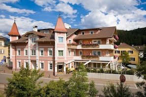 A pink building with a sign 'Hotel Bladburg' and a balcony with flowers. - Hotel Blitzburg (Brunico)