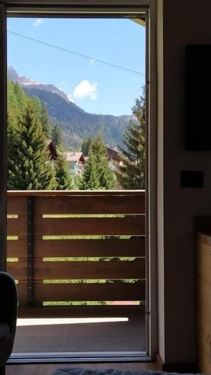 Habitación con vista a un paisaje montañoso a través de un ventanal.