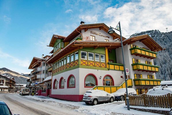 Un edificio de estilo alpino tradicional con varios balcones y un letrero que indica restaurante.