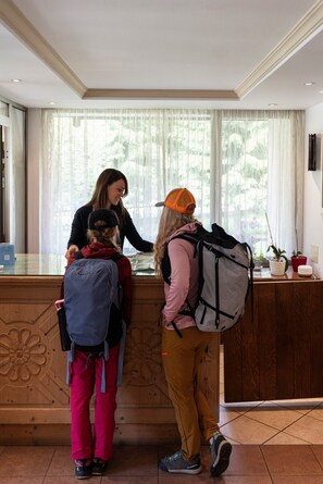 A reception desk with a woman assisting guests.