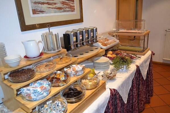 A buffet setup with various food items and beverages. - Corona (CARANO)