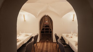 A dining area with tables set for two, a brick fireplace, and a vaulted ceiling. - Diana Dolomites  (Badia)