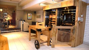 Ein Restaurant mit rustikalem Holzinterieur, einem großen Holztisch und einem eingebauten Ofen.