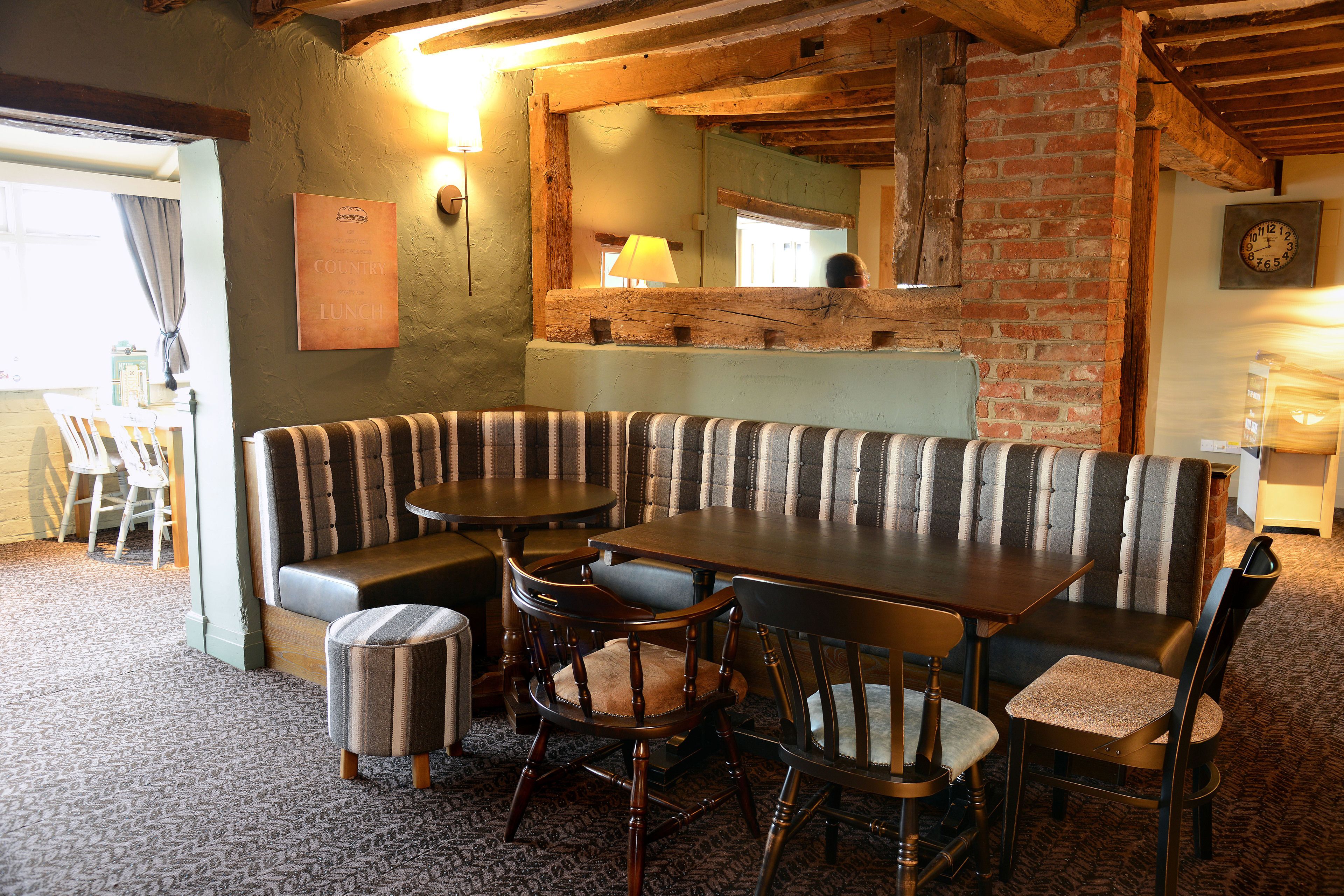 Un comedor acogedor con una mesa de madera y asientos tapizados a rayas.