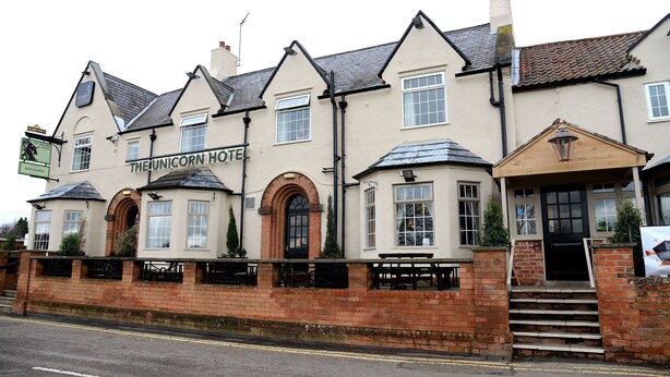 A traditional building with a sign reading "The Unicorn Hotel." It features a brick facade, multiple windows, and a staircase leading to the entrance. - Unicorn, Gunthorpe by Marston's Inns (Nottingham)