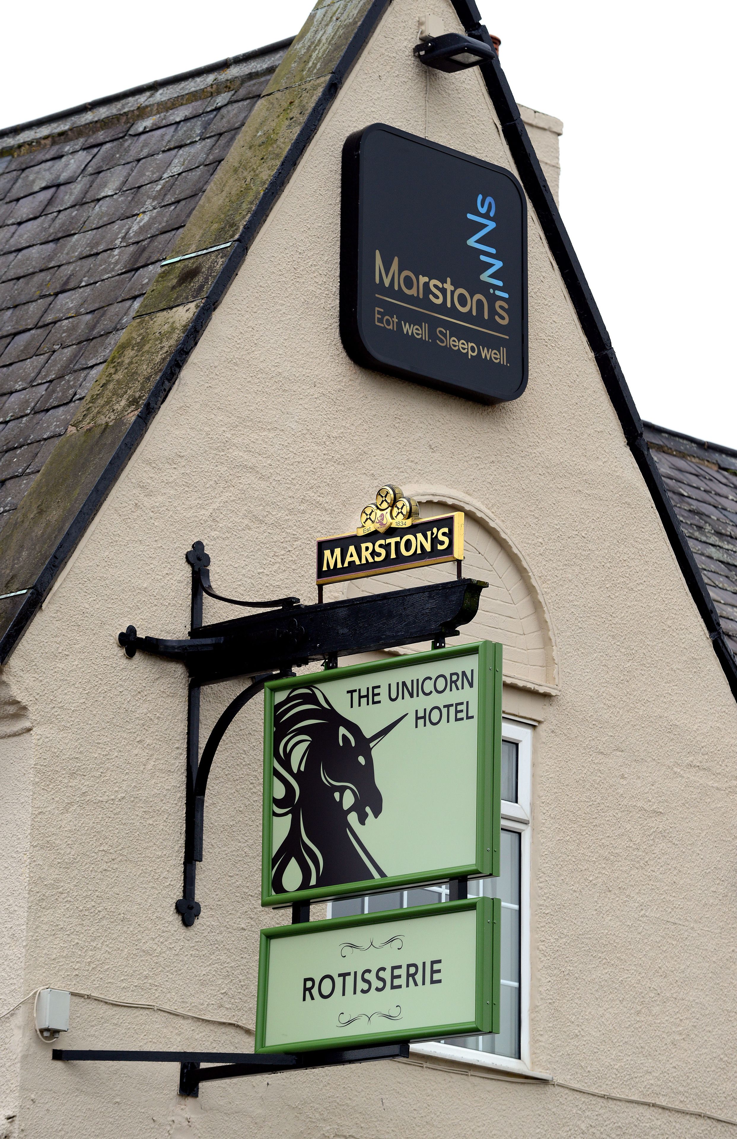 A building with signs for 'Marston's', 'The Unicorn Hotel', and 'Rotisserie'.