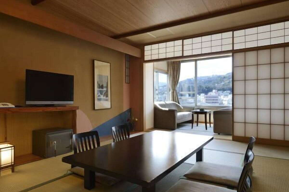 Une pièce de style japonais traditionnel, avec un sol recouvert de tatamis, une table basse et un canapé.