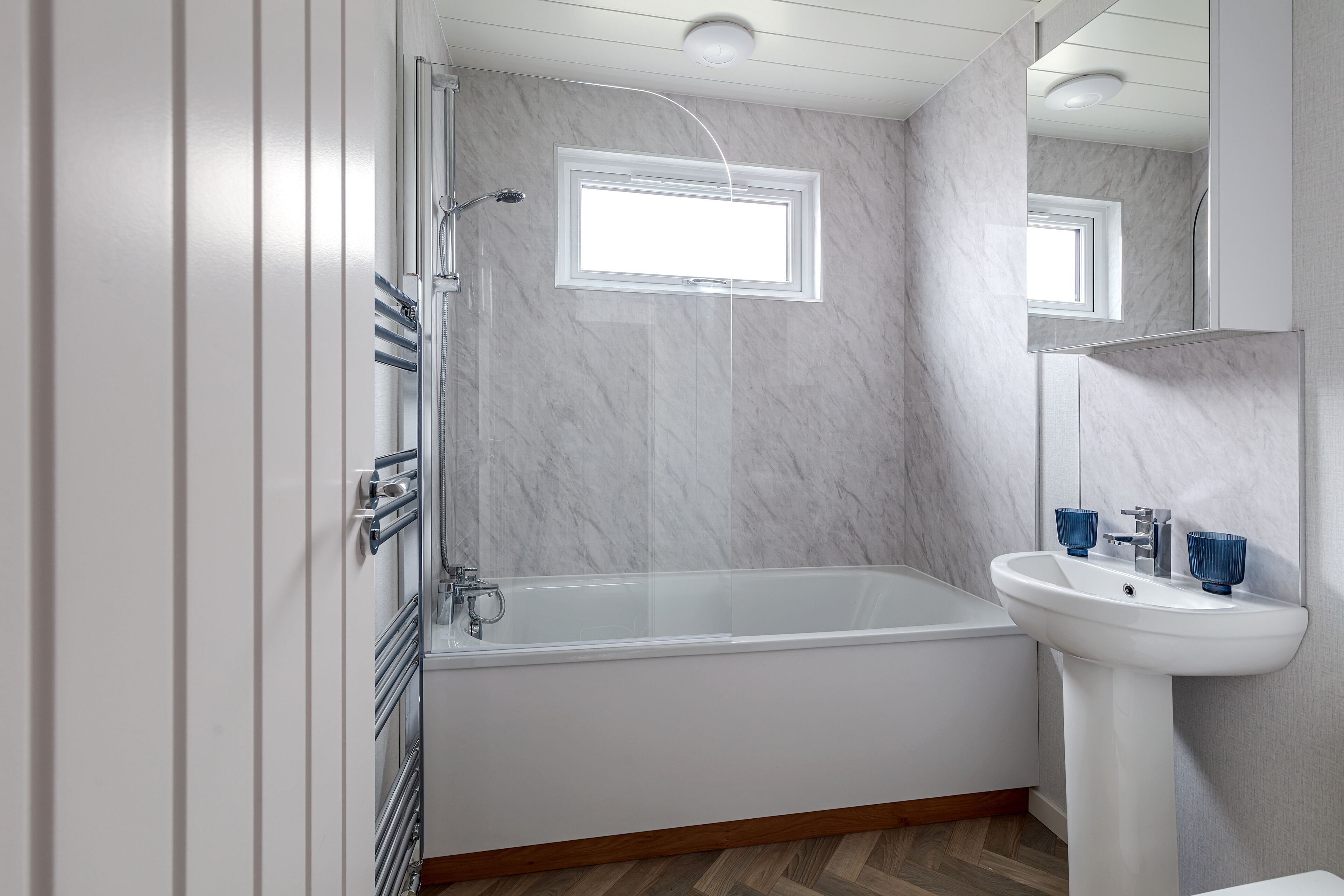 A modern bathroom with a bathtub, a sink, and a window.