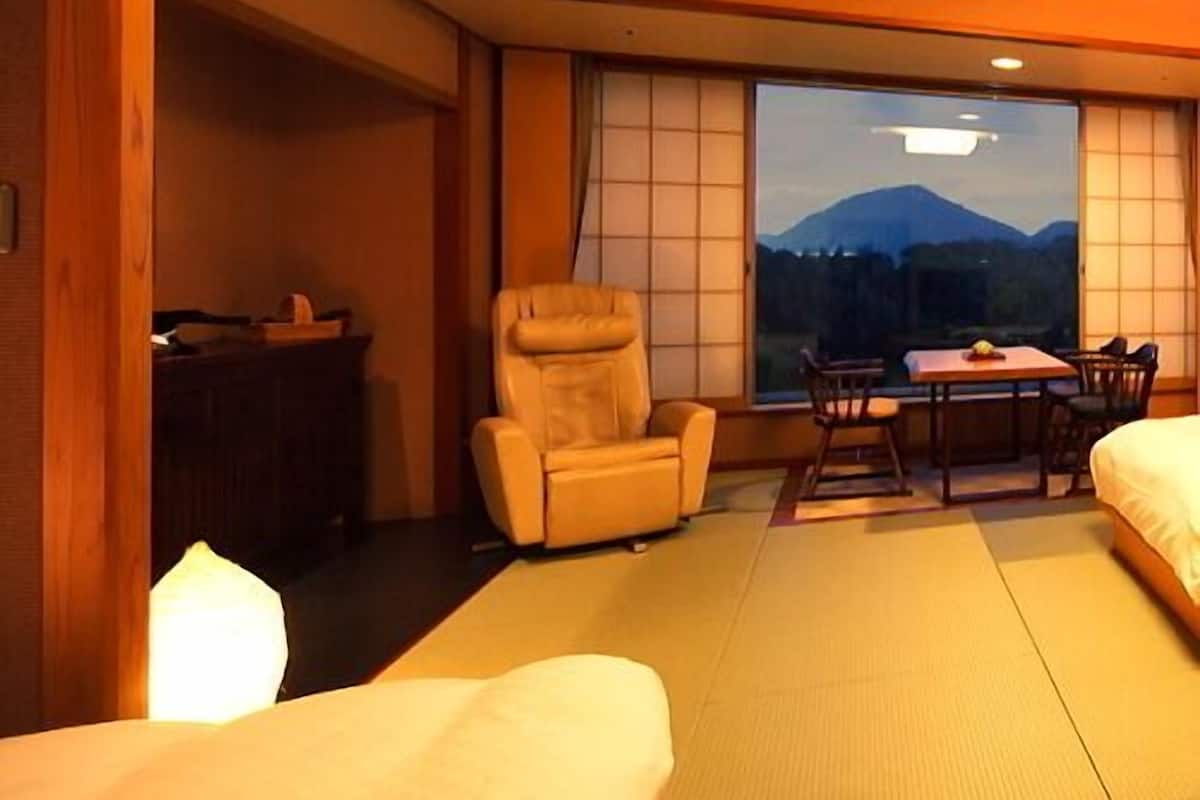 Une chambre avec un lit, une chaise, une table et une vue sur les montagnes.