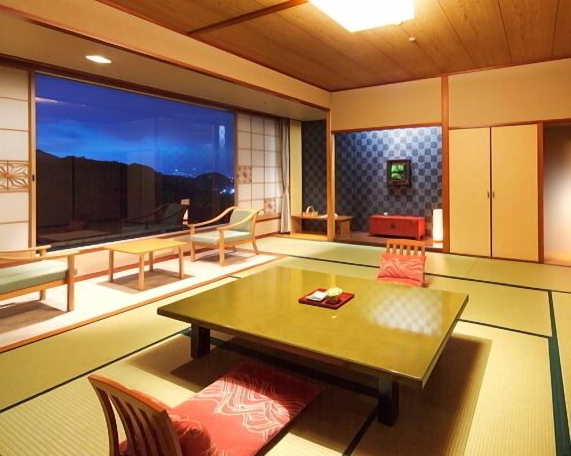 A traditional Japanese-style room with tatami flooring, a low table, and sliding doors.