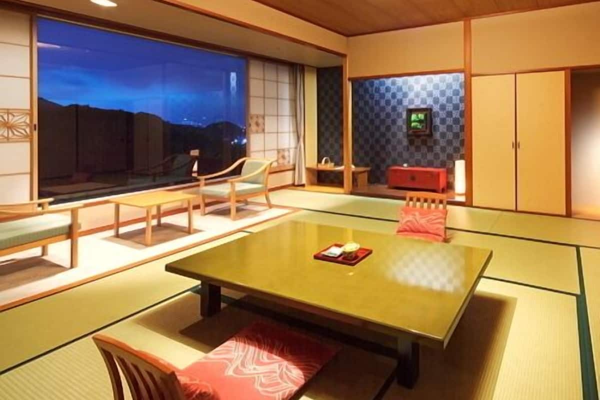 Une pièce de style japonais traditionnel, avec un sol recouvert de tatamis, une table basse et des portes coulissantes.