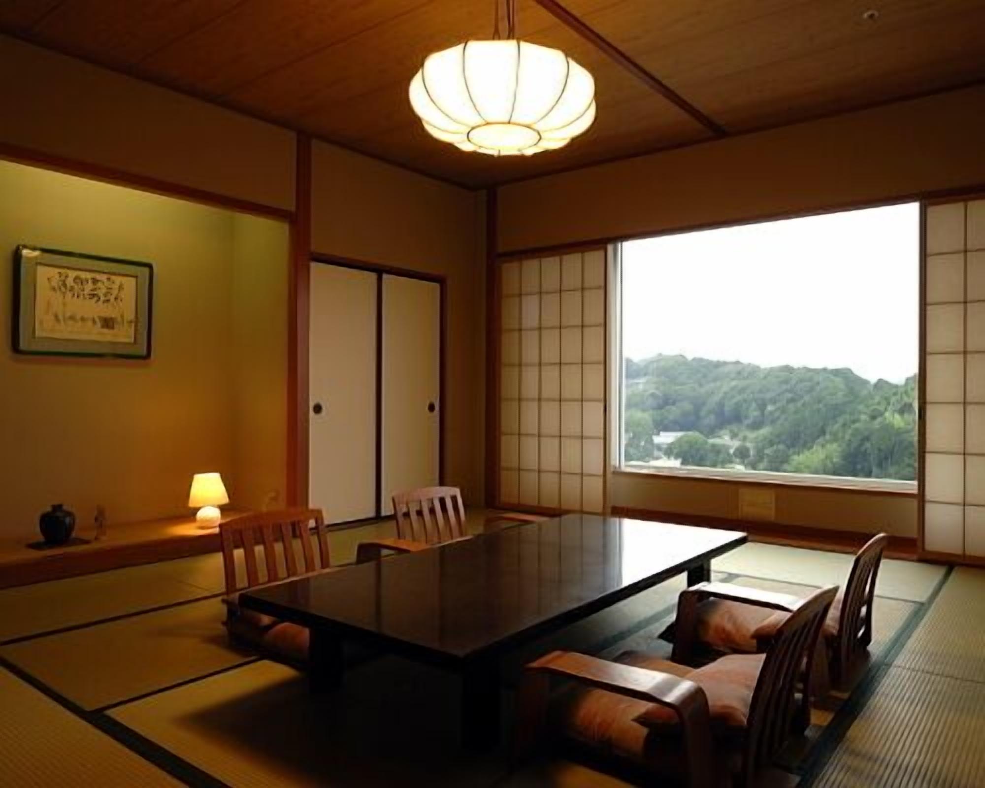 A traditional Japanese room with tatami flooring, a low table, and sliding doors.