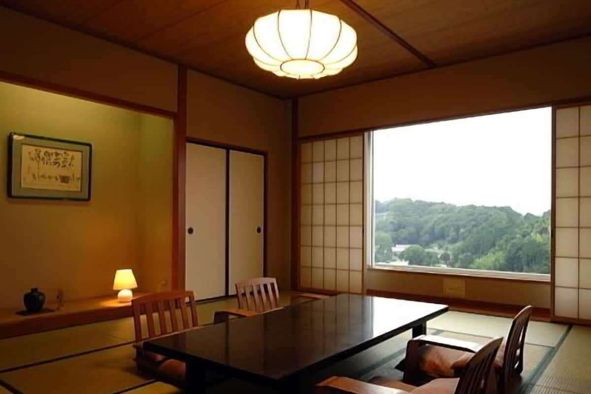Une pièce de style japonais traditionnel, avec un sol recouvert de tatamis, une table basse et des portes coulissantes.