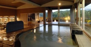Un espacio de spa con hidromasaje, asientos y vistas al exterior.