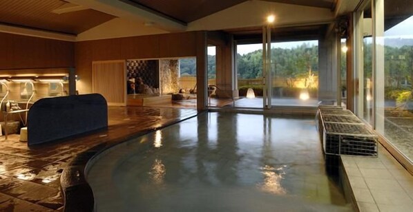 Un espacio de spa con hidromasaje, asientos y vistas al exterior.