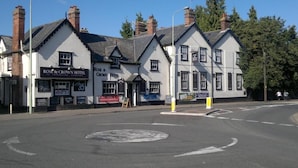 Un edificio tradicional con varias ventanas y un letrero que dice 'Rose & Crown Hotel'.