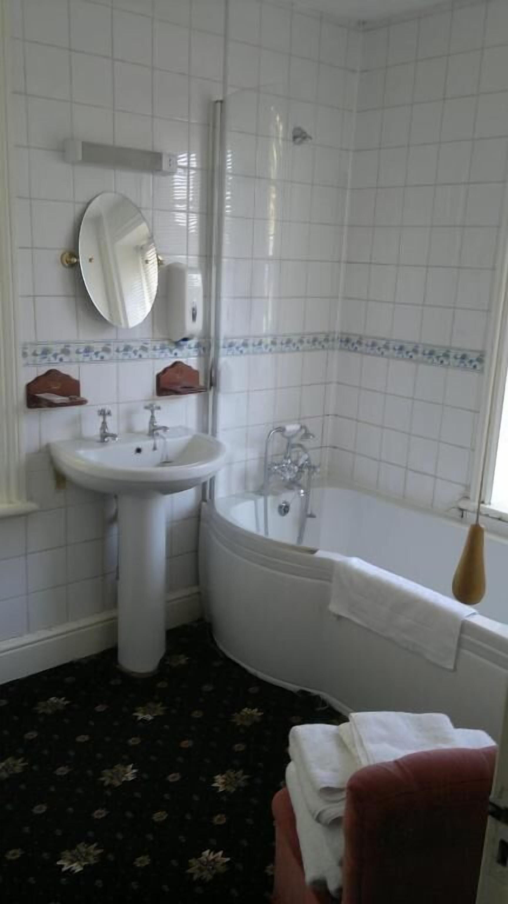 Un baño con lavamanos, espejo y bañera.
