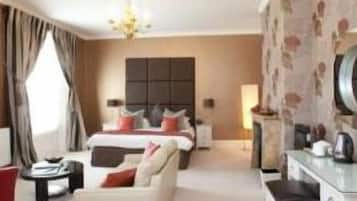Habitación de hotel con cama, sofá, escritorio y televisor.
