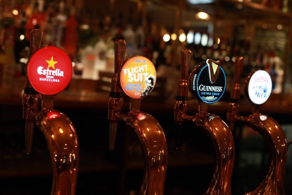 A bar with beer taps labeled with brands like Estrella, Flich Suit, and Guinness.