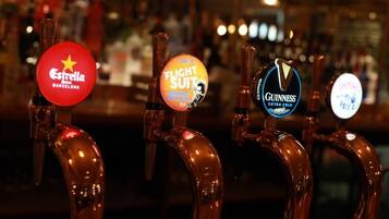 A bar with beer taps labeled with brands like Estrella, Flich Suit, and Guinness.