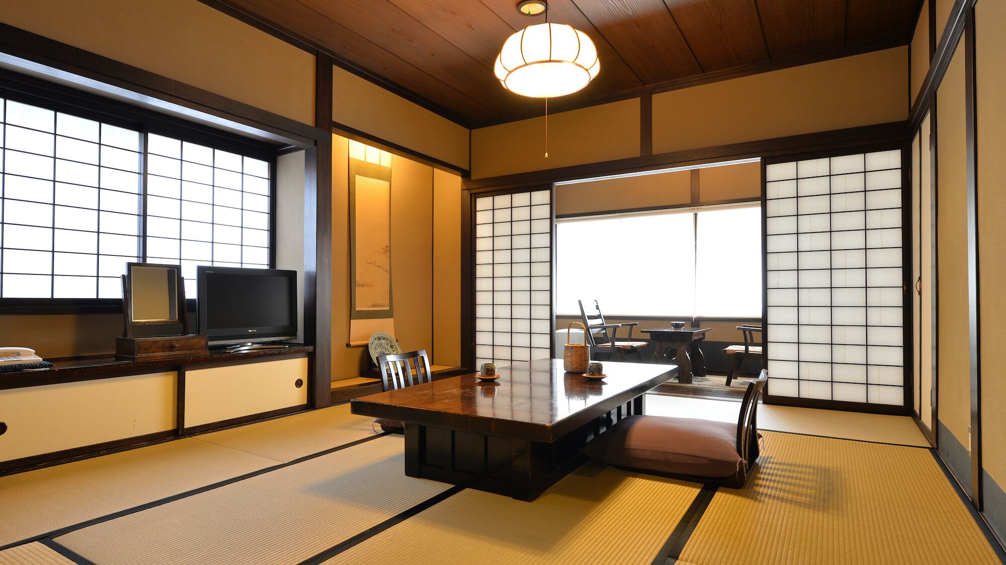 Een traditionele Japanse kamer met tatami vloerbedekking, een lage tafel en schuifdeuren.