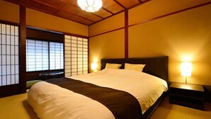 A traditional Japanese-style bedroom with tatami flooring, a low wooden ceiling, and shoji screens. - Ryokan Sugimoto (Matsumoto)